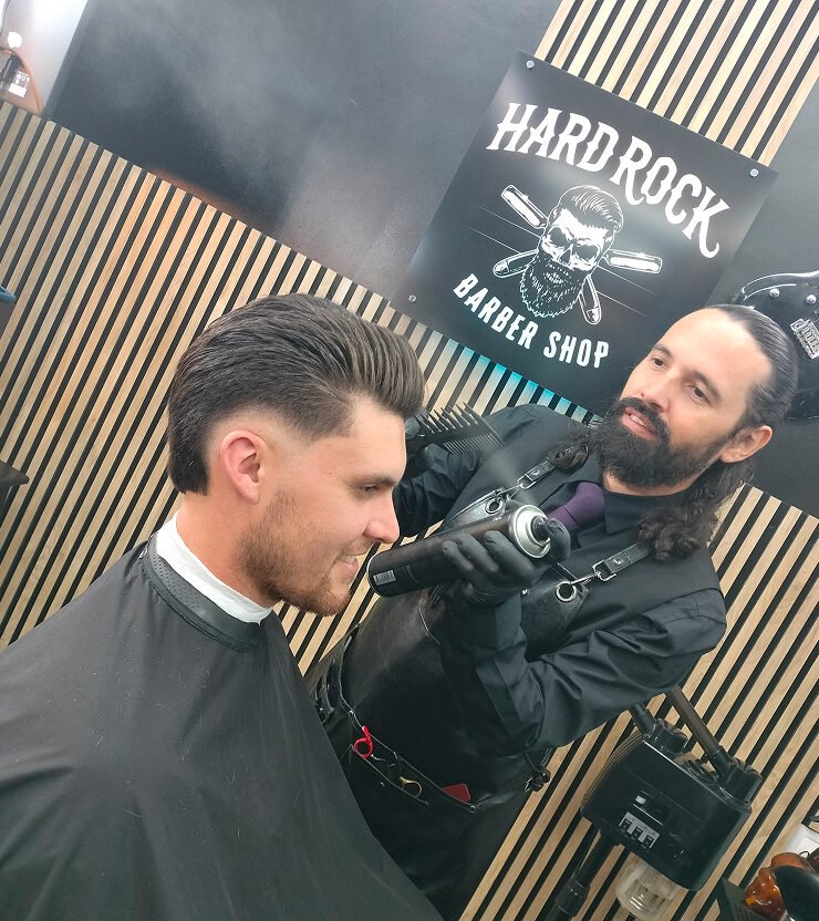 Barbero de Hard Rock aplicando el acabado a un corte degradado