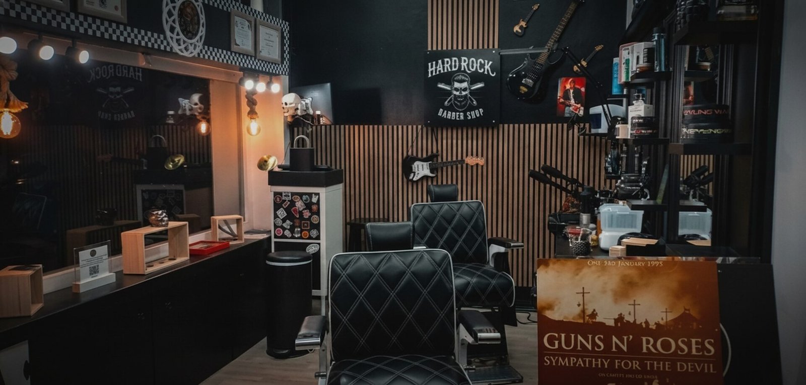 Interior de Hard Rock Barber Shop: sillones de barbero, guitarras y paredes de listones de madera